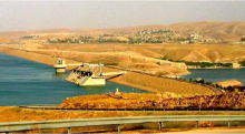 A landscape image of the Mosul Dam in Iraq, among a background of mountains.